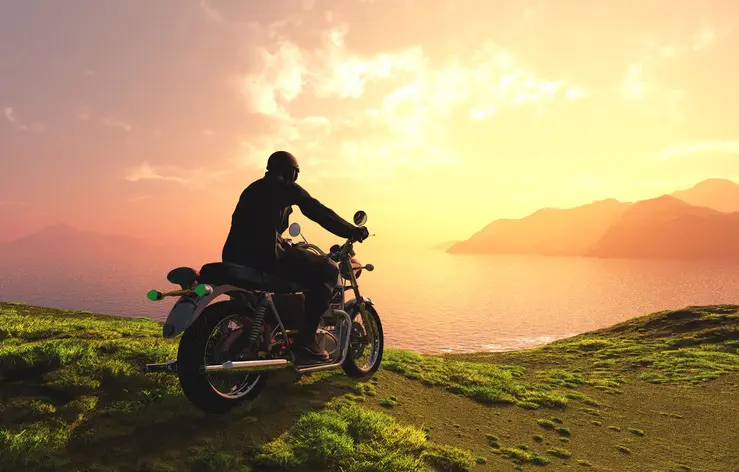 moto face à la mer au coucher de soleil