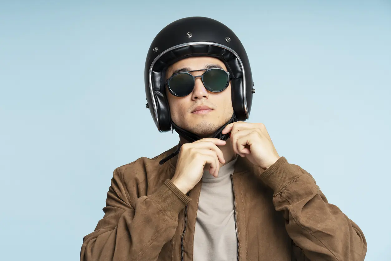 Homme mettant un casque pour faire de la moto avec un fond bleu