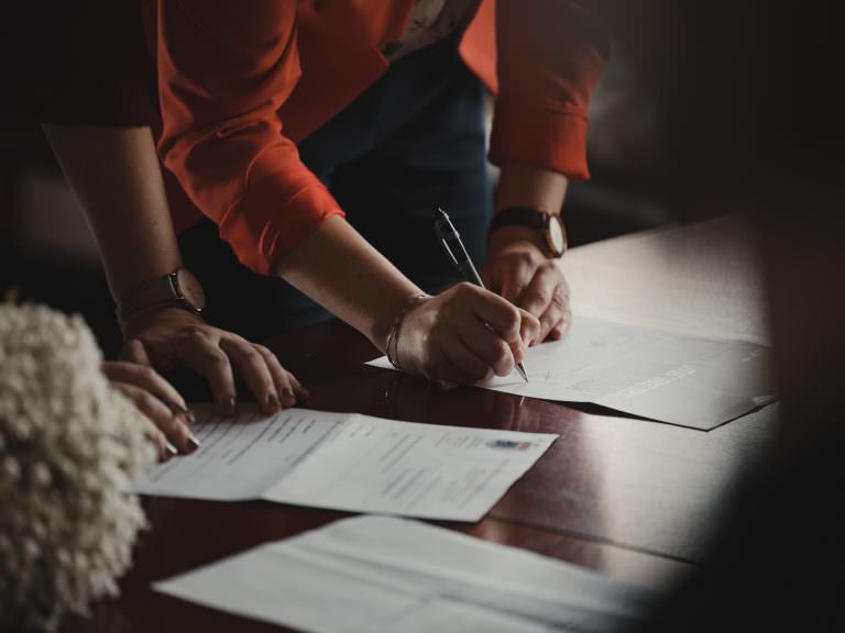 homme en train de signer en document