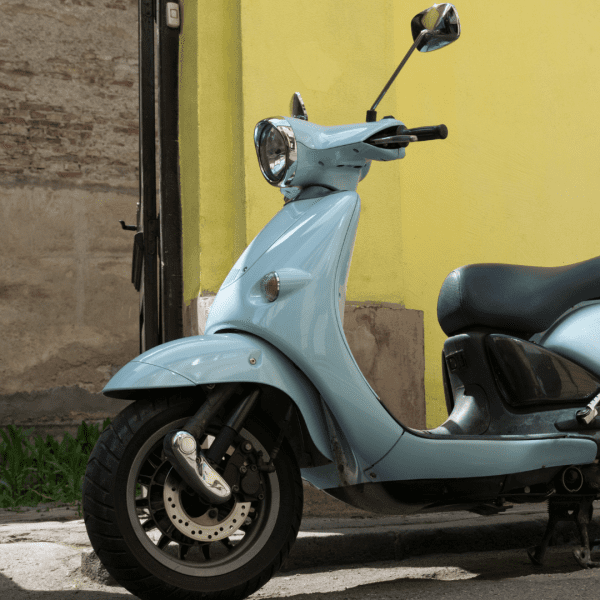 Scooter Bleu dans une rue avec le mur jaune