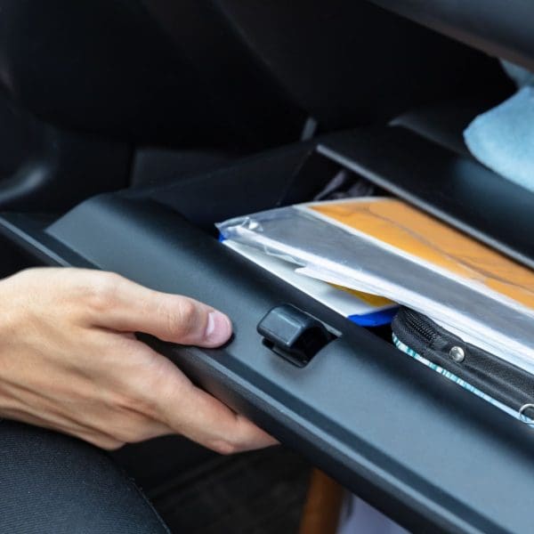 personne qui ouvre la boite à gant pour trouver des documents