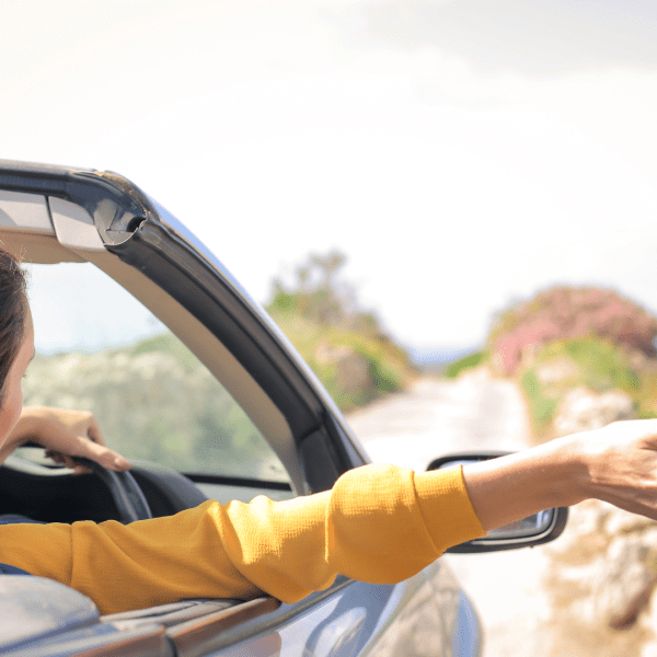 Photo femme voiture tendant la main par la fenêtre.