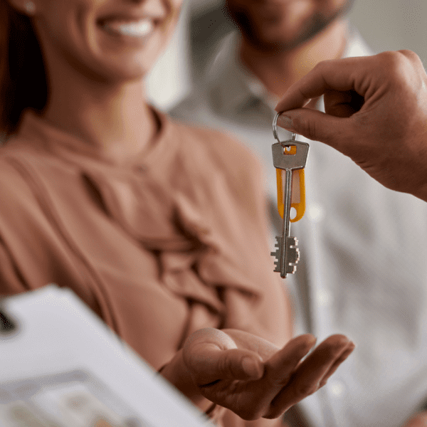 Un monsieur donne les clés d'un logement aux nouveaux propriétaires