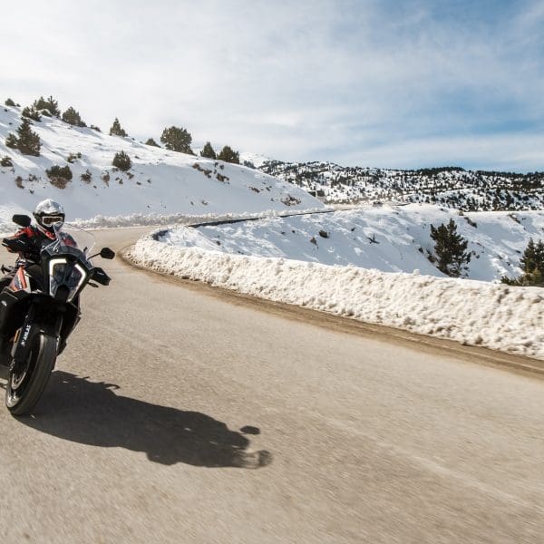 motard sur la route qui roule au bord de la neige