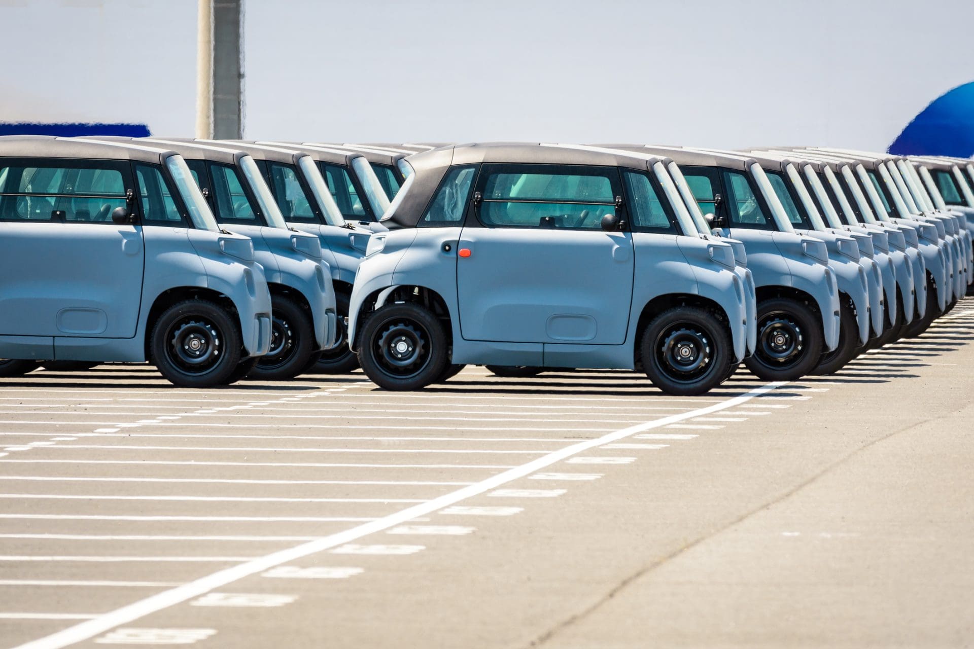 Des microcars électriques Citroën AMI flambant neuves alignées dans un parking