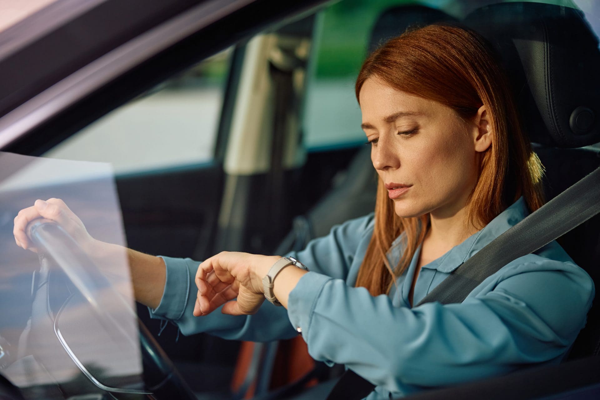 Femme qui est en train de conduire et qui regarde sa montre