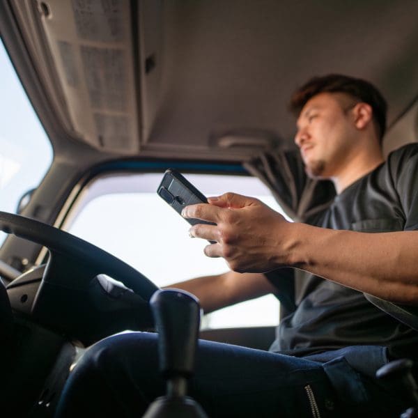 Chauffeur de camion conduisant tout en utilisant un smartphone